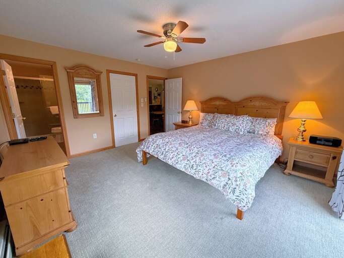 Primary bedroom with King bed, TV, walkout slider, and ensuite bath.