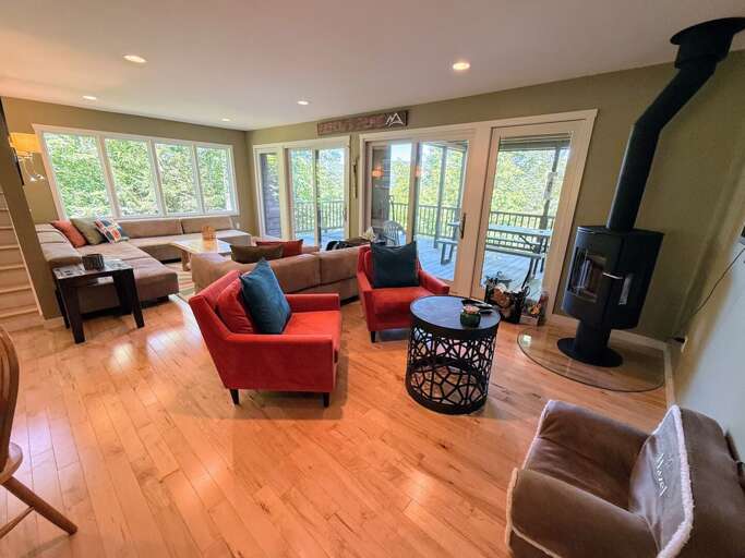 Main level living area with wood burning fireplace and TV and walkout access to outdoor table and mountain views.