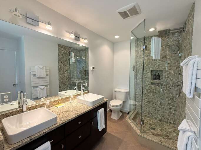 Upper level king bedroom ensuite bathroom with double vanity, custom shower and soaking tub.