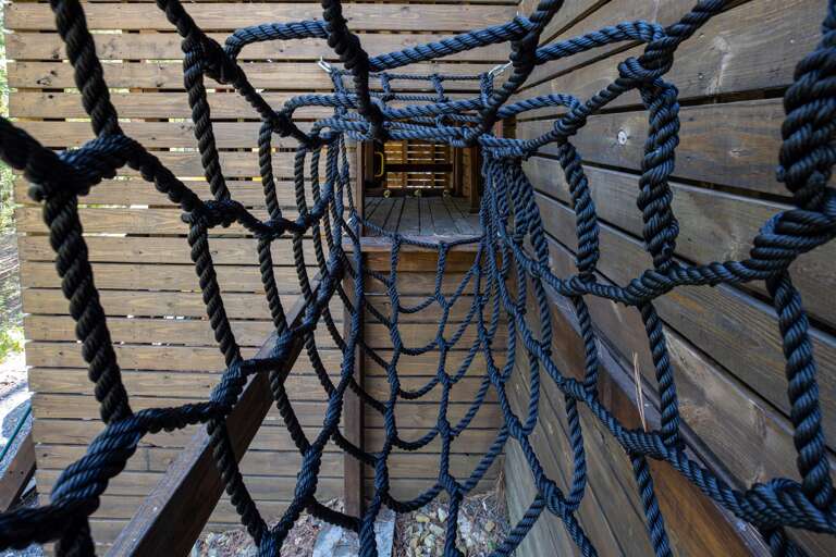 Rope net bridge to covered playset area