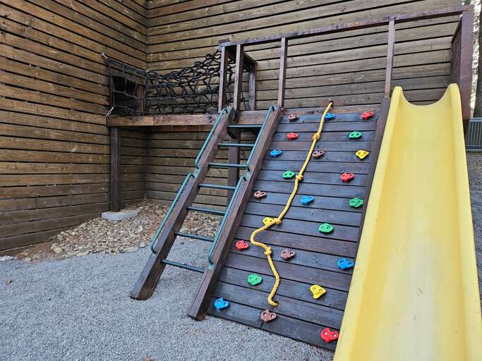Rock climing wall with Rope net entrance to inside playset structure