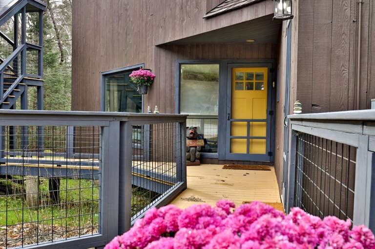 A cheerful yellow door welcomes you home. Leave your boots on the mat and step into vacation mode.