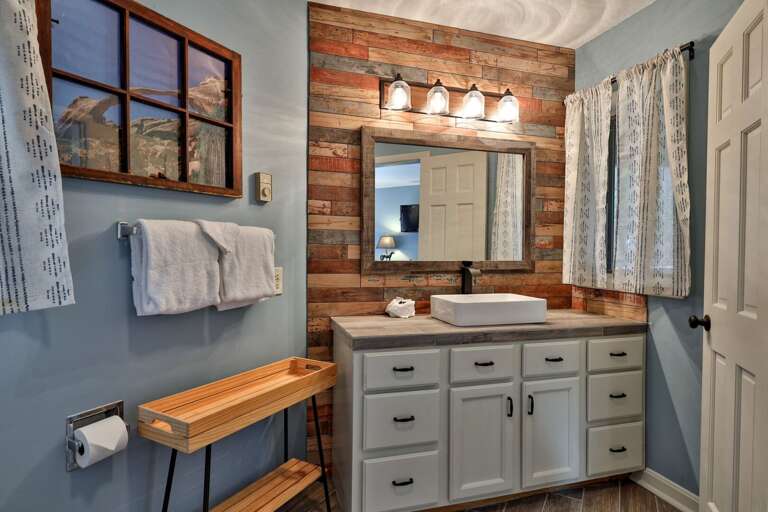 Custom reclaimed wood accent wall and vessel sink. Mountain character in every detail, not just standard builder-grade finishes.