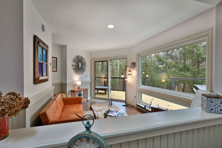 Huge picture windows frame the forest in the sunroom. A quiet spot to watch the snow fall after a day on the Killington slopes.