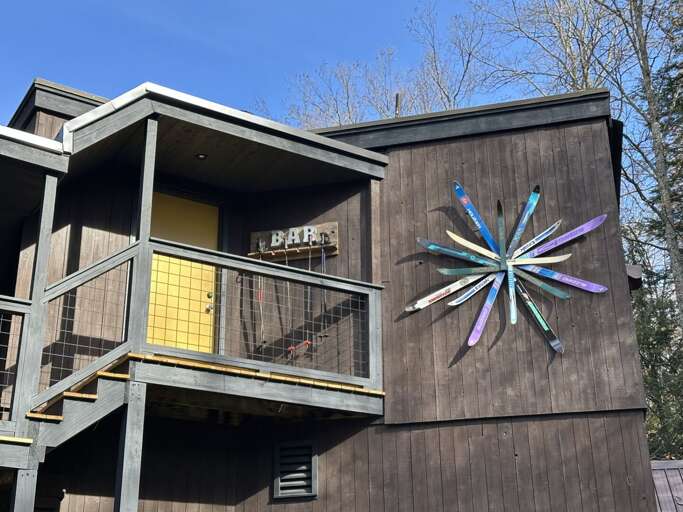Private entrance to the detached game room. The "BAR" sign and custom ski art set the tone for fun.