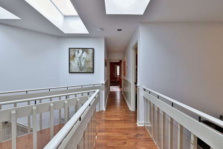 Skylights illuminate the second-floor landing. Bright, airy architecture that feels miles away from a standard hotel corridor.