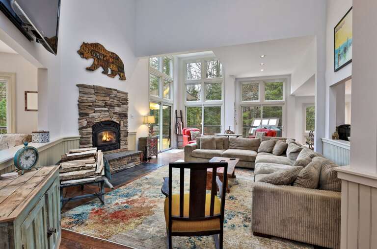 Vaulted ceilings and a stone fireplace anchor the living room. Space for the whole group to gather without feeling crowded.