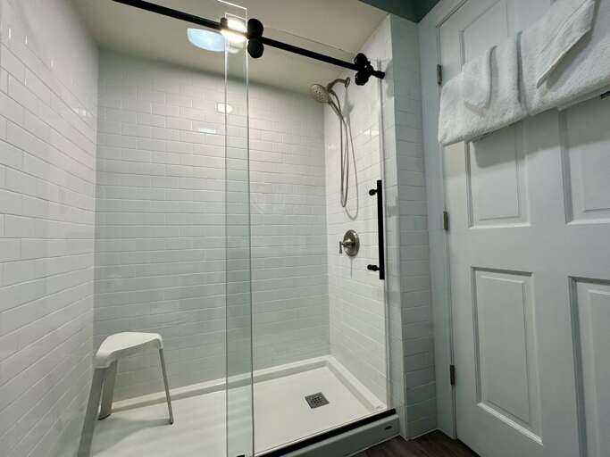 Experience a refreshing morning in the sleek bathroom, boasting a crystal clear glass shower stall and pristine toilet during your cozy vacation rental stay. Comfort designed for you!