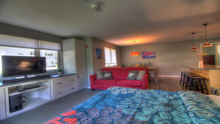 Experience the comfort of our cozy living room, equipped with a plush couch , queen bed, and a state-of-the-art TV for your entertainment needs.