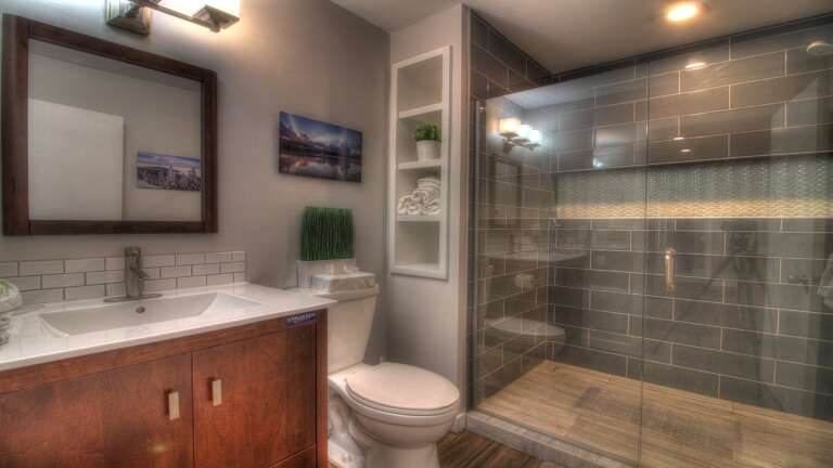 Experience the luxury of our bathroom, featuring a sleek glass shower stall.