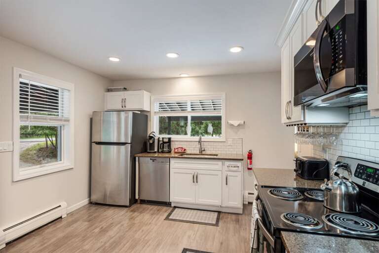 The refrigerator, range, microwave, and prep counters are arranged in a practical kitchen layout.