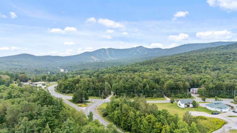 This summer aerial shows Killington's green slopes rising beyond the neighborhood.