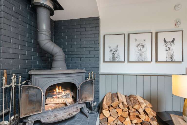 The woodstove and stocked hearth bring welcome warmth to the living room.