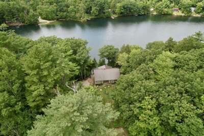 Aerial view of this renovated home on the shores of Fern Lake, surrounded by Vermont's rich, wooded landscape.