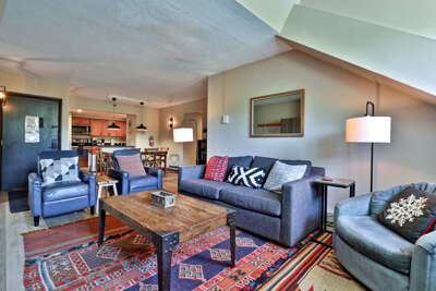 Alpine Vista's living room features a sleeper sofa, a fireplace, and ample seating in a thoughtfully decorated, relaxing space.