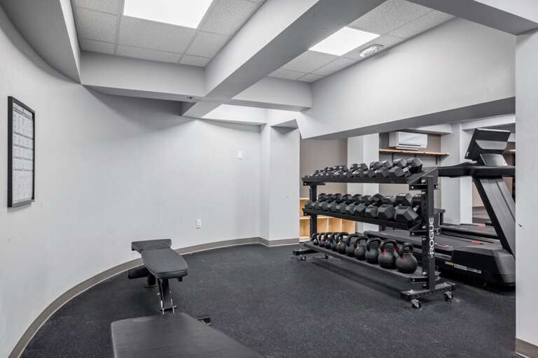 A bench and full dumbbell rack add strength training options to the shared fitness room.