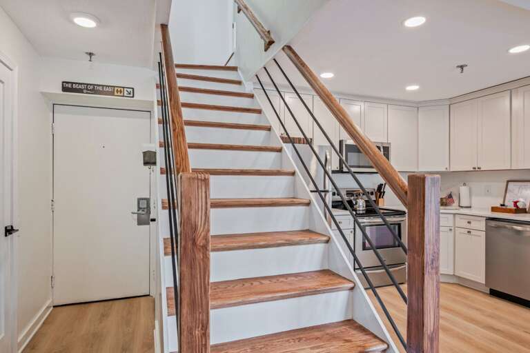 The open staircase links the entry and kitchen below with the bedrooms upstairs.