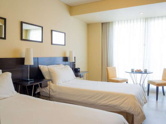 Room set up with two twin beds.