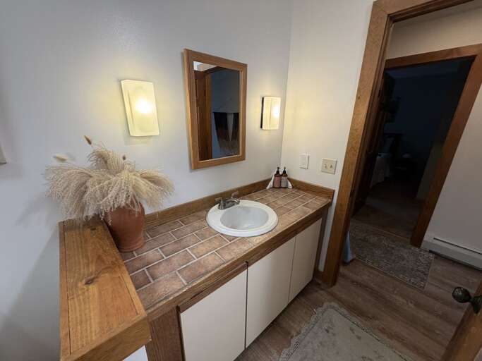The tiled vanity counter leaves space around the sink for daily essentials.