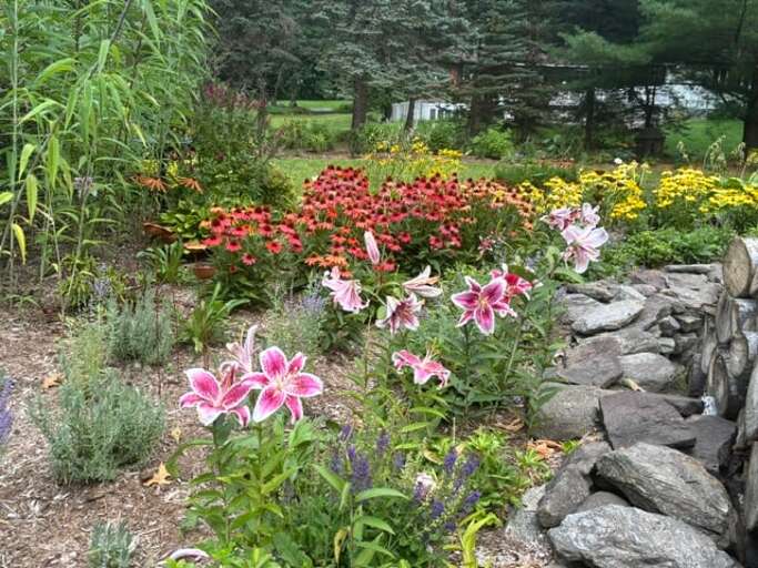 Colorful flowers fill the garden bed above its low stone edge.