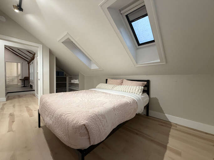 A light-filled second bedroom designed for restorative sleep and easy gear organization.