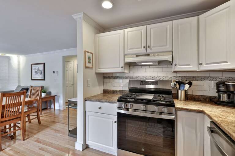 The gas range sits beside the opening to the dining area, so the cook need not be tucked away.