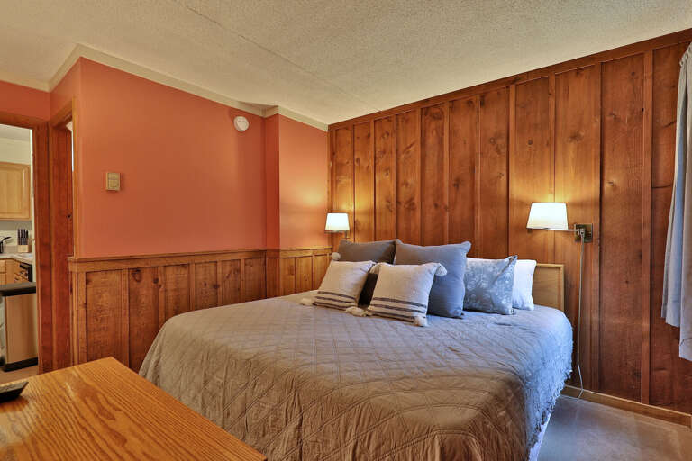 Experience the cozy comfort in our bedroom featuring charming wood paneling and a comfortable bed, perfect for relaxation. This will undoubtedly elevate your stay to new heights.