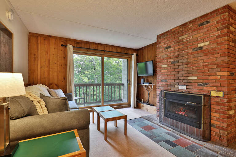 Experience ultimate comfort in our cozy living room, featuring a warm fireplace and a large TV.