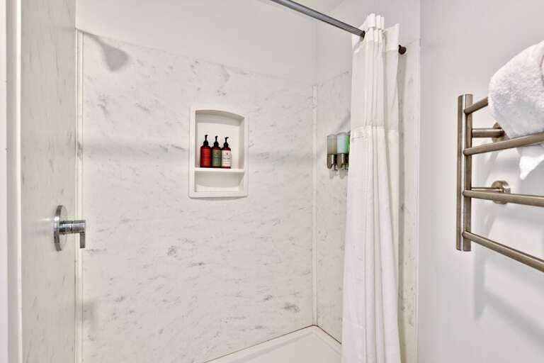 A bright walk-in shower and heated towel rack complete this upstairs full bathroom.