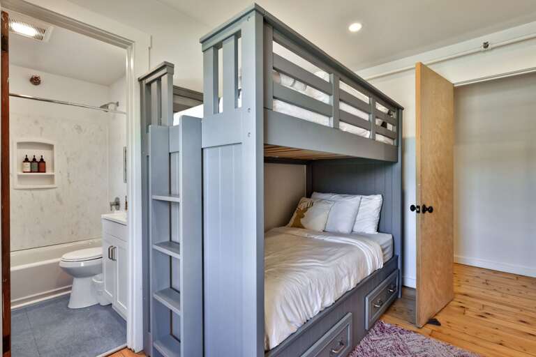 The bunk room places its sleeping spaces close to a full bathroom for an easy morning routine.