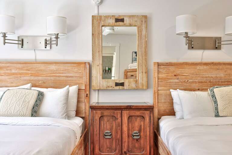 A dresser and mirror between the beds add useful storage and a second place to get ready.