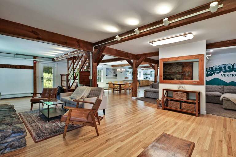 The open layout connects the fireplace lounge, dining area, and main TV room across the first floor.