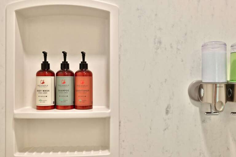 A recessed shelf keeps bath products within easy reach without cluttering the tub ledge.