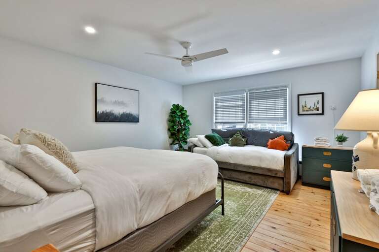 A roomy bed and separate daybed create a comfortable upstairs retreat with extra sleeping flexibility.