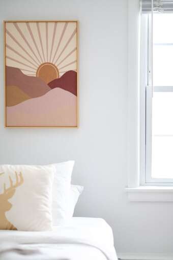 Single bed in the bunk room beneath a window with wall art and a bedside table.
