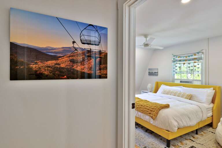 Ski-area artwork brings a subtle sense of place to this spacious upstairs bedroom.