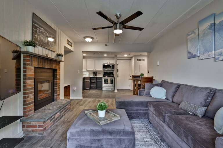 Kitchen, dining, sofa, and balcony flow together in a compact layout built for time together.