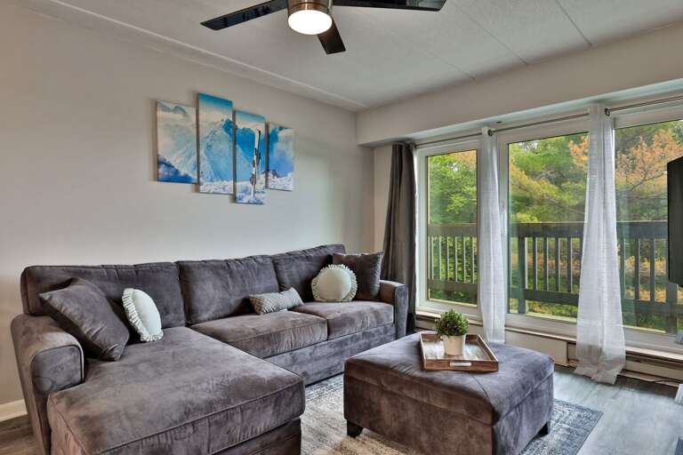 Stretch out on the sectional while the glass doors frame treetops and summer light.