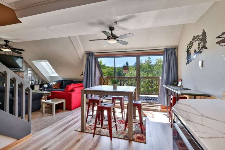 The dining table sits between the kitchen, living room, and balcony for an easy group layout.