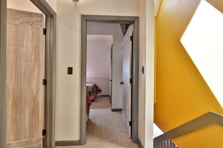 The short interior hall connects the sleeping areas and bathrooms within the condo.