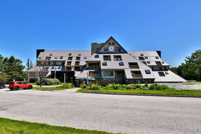 A wide exterior view shows the scale and alpine-style architecture of the Mountain Green complex.