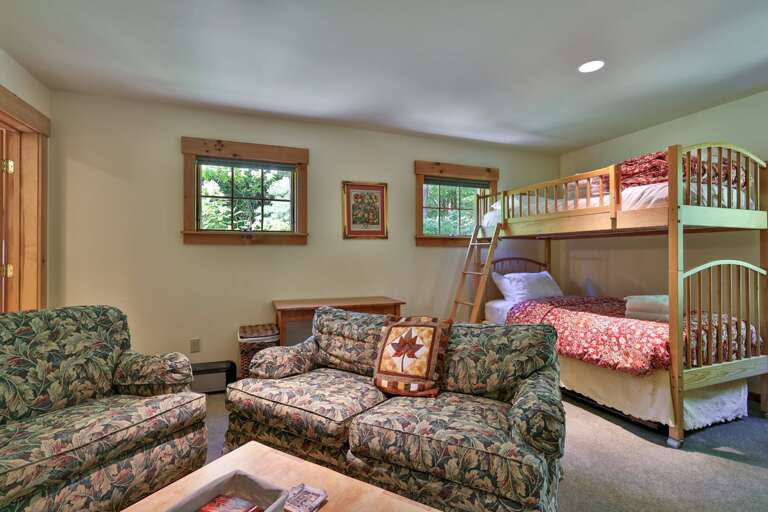 A bunk bed and separate lounge seating create a flexible room for sleeping, movies, and downtime.