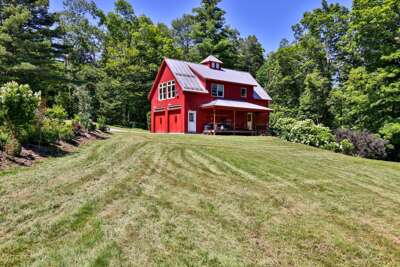 A classic red Vermont barn and expansive lawn set the scene for a relaxed country stay.