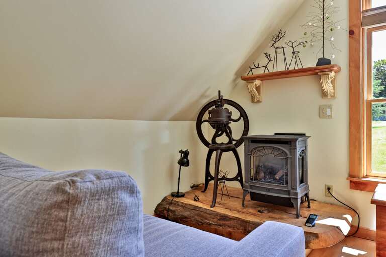 A compact wood stove and antique barn tool give the living room a distinctive sense of place.