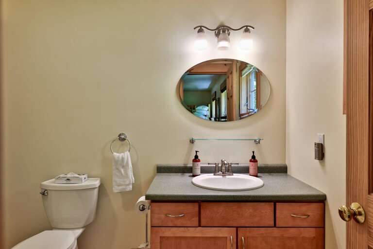 The lower full bathroom pairs a wood vanity with a walk-in shower just out of view.
