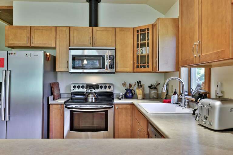 A full-size refrigerator, range, microwave, and toaster cover the essentials for cooking at home.