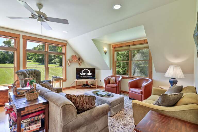 Settle into a sunlit living room where wide windows frame the lawn and gardens.