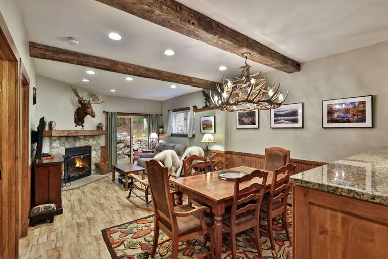 Dinner comes with warm wood details, exposed beams, and a real fire glowing nearby.