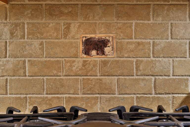 A small bear tile tucked into the stone backsplash adds a playful local touch.