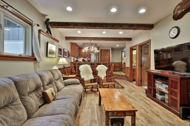 The sofa, fireplace, dining table, and kitchen share one open space, so the evening stays together.